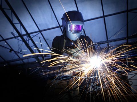Portrait von Stefanie Welk. Schweißarbeiten an einer Drahtskulptur im ehemaligen Atelier in Heidelberg.